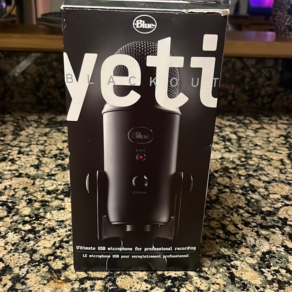 Yeti blue microphone with charger and foam pop filter.